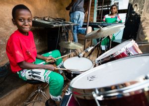 Young African boy playing drums