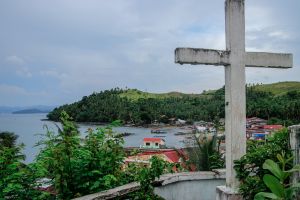 Stone cross with rural Philippines village
