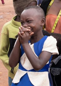 Little African girl laughing and hands covering her mouth