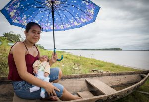 Latin American young mom with baby and umbrella