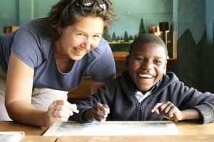 White woman with African child drawing together